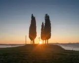 Alba in Toscana con cipressi e croce, un'immagine HDR a.