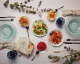 Un repas végétarien servi à l'assiette : houmous, salade, carottes et betterave. Une belle définition du service à l'assiette.