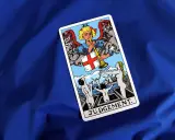 Karta Sąd Ostateczny Tarot. Anioł gra na trąbie, budząc ludzi z grobów.