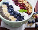 Miseczka pełna super foods: jagody, banany, nasiona chia, płatki kokosa, żurawina i granola. Idealne śniadanie.