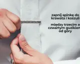Mężczyzna zapina spinkę do krawata i koszuli między trzecim a czwartym guzikiem od góry. Elegancki sposób na noszenie spinki.