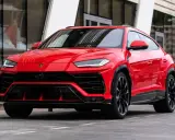 Un imponente Lamborghini Urus rojo, listo para la acción, con su diseño agresivo y llantas negras.