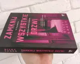 Okładka książki "Zamknij wszystkie drzwi" z różowymi neonowymi literami na czarnym tle.