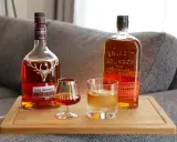 Zwei Flaschen Whiskey, Dalmore und Bulleit Bourbon, und zwei Gläser zeigen die whiskey unterschiede.