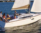 Un voilier Sun Odyssey 349 navigue avec une famille. La fiche technique de ce bateau est idéale pour des vacances en mer.