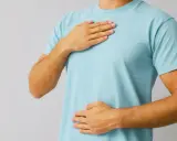 Person med händerna på bröstet och magen, kanske för att lugna en stressad mage.