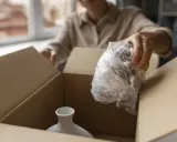 Otwieranie paczki od Hermes Niemcy. Delikatna waza w folii bąbelkowej czeka na wyjęcie z kartonu.