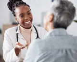 Doctora sonriente explica a paciente sobre síntomas de clamidia en mujeres, ofreciendo apoyo y claridad.