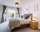 Chambre lumineuse avec lit douillet, accès balcon et décoration murale "Me and you". Idéal pour louer une partie de sa résidence principale.