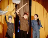 Niños en un escenario, listos para obras de teatro para niños. Uno sostiene una espada, otro una luna y una varita mágica.