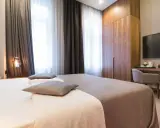 Eleganckie pokoje hotelowe: łóżko, szafa, biurko z TV. Idealne nazwy pokoi hotelowych dla komfortowego pobytu.