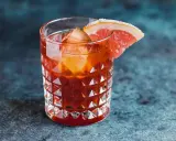Orzeźwiający koktajl z Jägermeister, lodem i plasterkiem grejpfruta na krawędzi szklanki.
