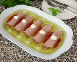 Roladki z szynki z papryką w galarecie, ozdobione kleksami majonezu. Elegancka przystawka na specjalne okazje.