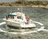 Un bateau navigue en mer, entouré d'une ancre virtuelle. Des personnes sont sur le pont, profitant de la croisière.