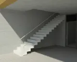 Nowoczesne schody dywanowe na beton, z jasną poręczą, w minimalistycznym wnętrzu.