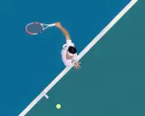 A tennis player in mid-serve, racket raised, on a blue and green court. The white lines of the court are like brad walls, guiding the game.
