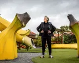 Konstnären Åberg står stolt vid en lekplats med gigantiska bananer.