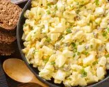 Cremiger Eiersalat mit Gurkenstückchen und Schnittlauch, garniert, serviert mit Vollkornbrot. Ein einfaches eiersalat rezept.