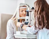 Kobieta z blond włosami u optometrysty, badanie wzroku. Czyżby to było zamglone widzenie po przebudzeniu?