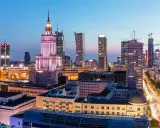 Warszawski krajobraz miejski nocą, z Pałacem Kultury i Nauki w centrum. Wiele nowoczesnych budynków, gdzie znajdują się uczelnie prywatne Warszawa.