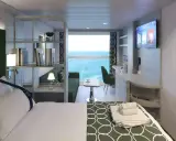 Interno cabina MSC World Europa: letto, divano, scrivania e vista mare.