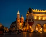 Wieczorny spacer po Rynku Głównym w Krakowie. Sukiennice i Kościół Mariacki oświetlone, tworzą magiczną atmosferę na udany weekend w Krakowie.