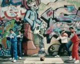 A group of young people showcase their moves in front of vibrant graffiti art, embodying the spirit of hip hop culture art.