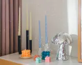 En samling av DIY ljus i olika former och färger, inklusive bubbel- och vridna ljus, samt en glittrig svampformad dekoration.