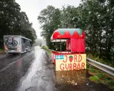 Regnig dag vid vägkanten med en jordgubbsförsäljning. Husbilen passerar, kanske på väg till sommarstugan under fruntimmersveckan, som bondepraktikan säger.