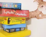 Stos gier planszowych, idealnych do wspólnej zabawy. Wśród nich "Lis i Urwisek", "Potwory do szafy" i inne gry coop.