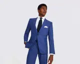 A man in a sharp blue suit, white shirt, and dark tie. This image helps answer how much should a suit cost.