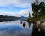 Zwei Kanus auf dem Loch Ness, umgeben von schottischen Highlands. Vielleicht sucht Nessie nach Gesellschaft?