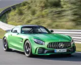 Grüner Mercedes-AMG GT R auf Rennstrecke, Fahrer im Fokus.