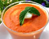 Un verre de gaspacho tomate, garni d'une feuille de menthe et d'une boule de mozzarella. Parfait pour se rafraîchir.