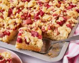 Saftiger Rhabarberkuchen mit Streuseln auf Hefeteig, frisch aus dem Blech geschnitten.