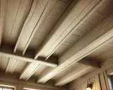 Plafond avec poutres peintes couleur lin, créant une ambiance chaleureuse et rustique.