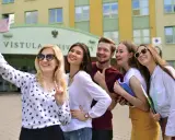 Studenci filologii angielskiej w Warszawie robią sobie selfie przed Uniwersytetem Vistula.