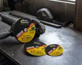 Amoladora con discos de corte de distintos tipos y tamaños, listos para trabajos de metalurgia.