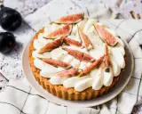 Tarte aux figues fraîches et crème fouettée, décorée de feuilles d'or.