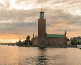 Stadshuset i Stockholm vid solnedgången. En vacker vy som inspirerar till roliga saker att göra i Stockholm, som en båttur eller promenad längs vattnet.