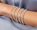 Bracciale tennis, un gioiello scintillante che ricorda la linea di un campo da gioco, indossato su un braccio.