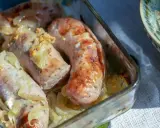 Aromatyczna, pieczona biała kiełbasa z cebulką i musztardą w szklanym naczyniu.