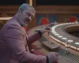 Dragomir Mrsic i en rosa kavaj vid ett runt bord, redo för nya filmer och tv-program.