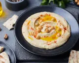 Pyszny, kremowy hummus co to jest? To pasta z ciecierzycy, oliwy, czosnku i przypraw, podana z pitą.