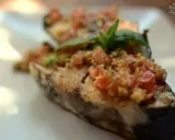 Deliciosa corvina a la plancha con un sofrito de tomate y hierbas frescas, servida en un plato blanco.