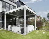 Une pergola moderne avec salon de jardin, offrant un espace extérieur confortable. C'est une définition pratique de pergola.