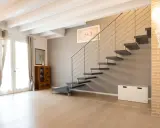 Moderna scala a sbalzo, con gradini scuri e corrimano in metallo. Soluzioni per chi cerca un design audace.