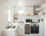Aménagement petite cuisine 2m2 : évier, plaque induction, four, micro-ondes et rangements optimisés dans un espace minimaliste et lumineux.