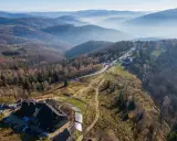 Widok na górskie krajobrazy i architekturę w Ustroniu. Widać parkingi, budynek z drewnianą architekturą i szlaki turystyczne.