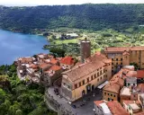Nemi, un borgo incantevole a breve distanza da Roma, si affaccia sul lago. Case con tetti rossi si aggrappano alla collina, circondate da verde lussureggiante.